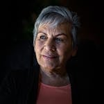 Elderly woman with gray hair looking thoughtfully, showcasing wisdom and grace.